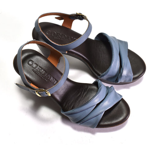 Pair of sandals with blue straps and black soles on a white background