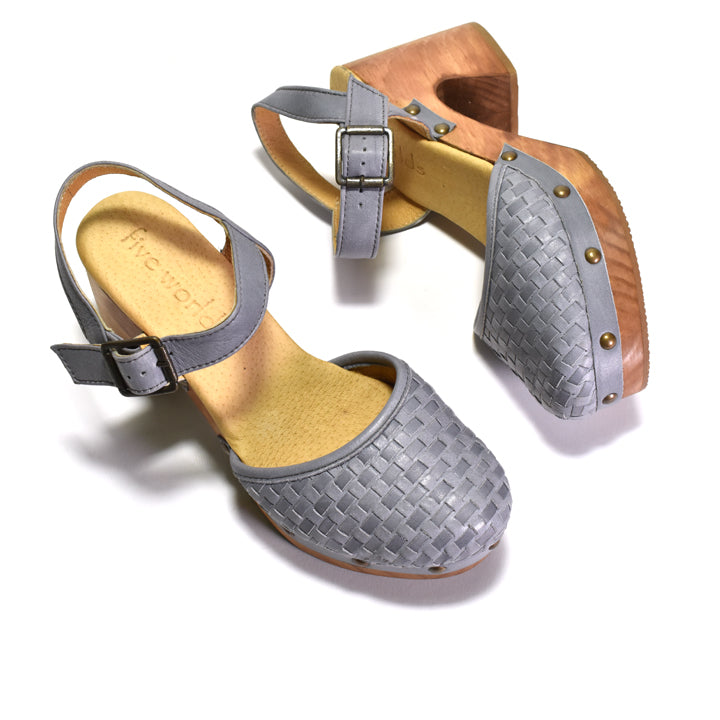 A pair of women's clog sandals with woven gray leather uppers, adjustable ankle straps with silver buckles, and light brown wooden clogs, shown on a white background.