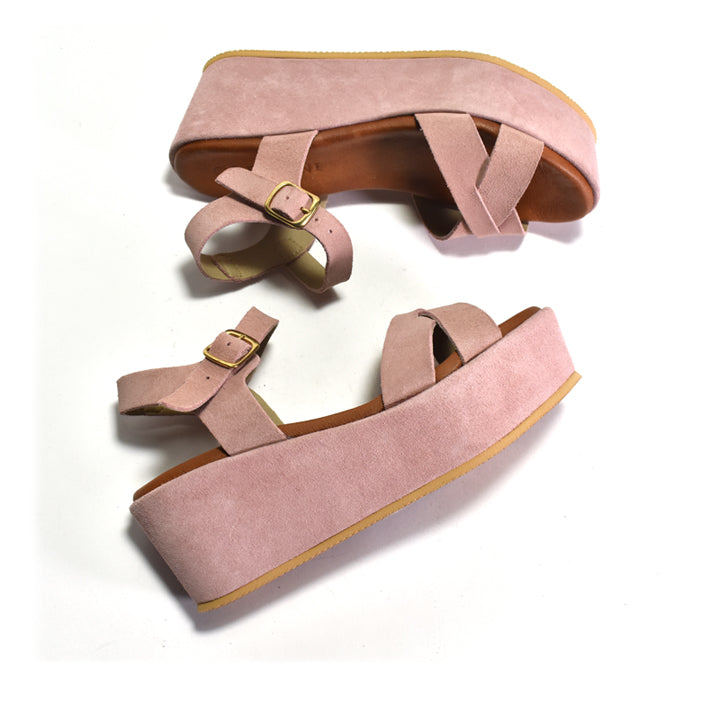 Pair of pink suede platform sandals on a white background