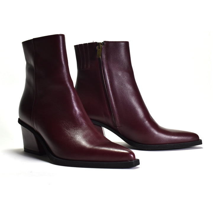A pair of dark burgundy leather ankle boots with low block heels and side zippers, shown on a plain white background.