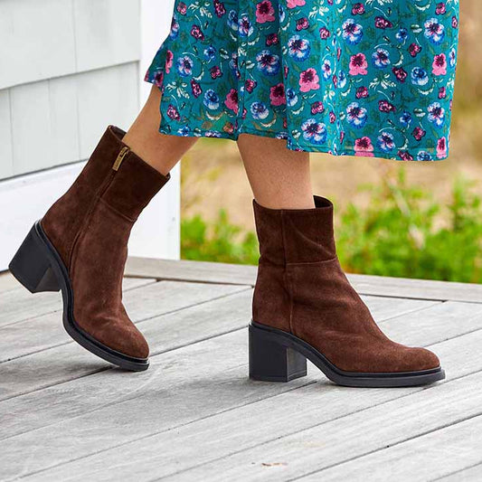 A brown suede ankle boot with a rubber heel and inside zipper
