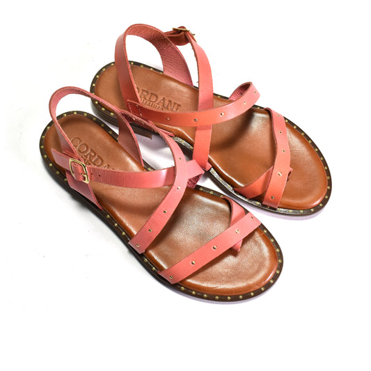 Pair of coral sandals with brown soles on a white background