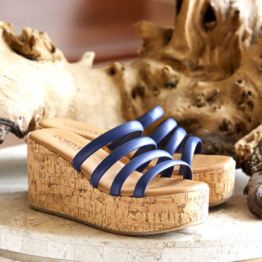 Blue sandals with cork wedges on a wooden surface