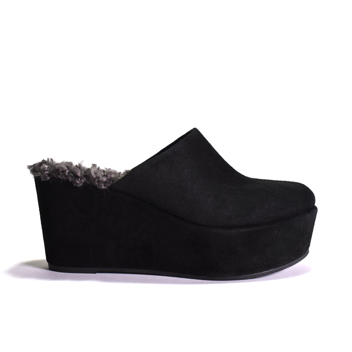 Black platform clog shoe with faux sheerling lining on a white background