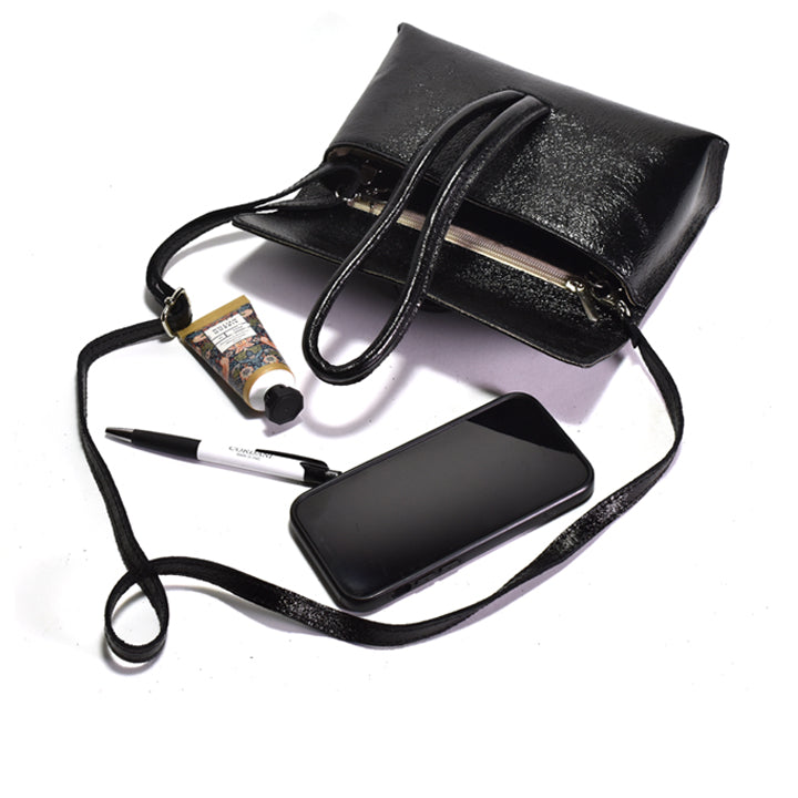 Black laminated leather clutch with strap and phone, pen and lotion