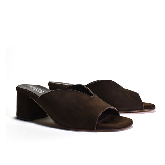 A pair of dark brown suede mule sandals with a low block heel, shown on a clean white background.