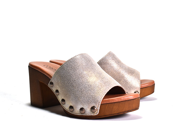A brown pair of sandals with a shimmering lip pattern on the upper and a stud detail on the wood-like platform. The sandal has a lightly padded leather footbed and a rubber sole.