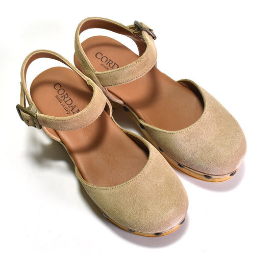 A pair of beige suede Mary Jane-style flats with ankle straps and buckle closures, shown on a clean white background. The brand name 'Cord' is visible on the insoles.