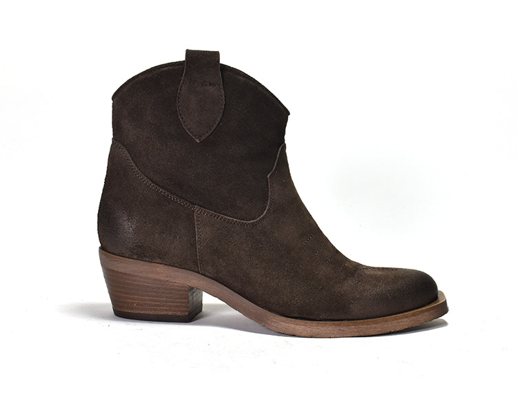 A brown suede western ankle boot with a distressed embroidered toe, an inside zipper, and a low heel, set against a white background.