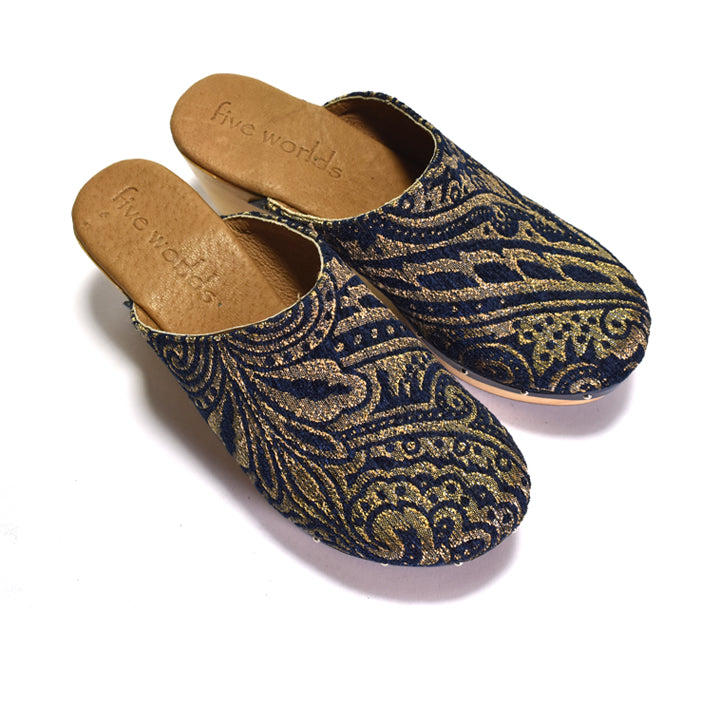 A navy blue and gold floral patterned clog with a wooden platform wedge.