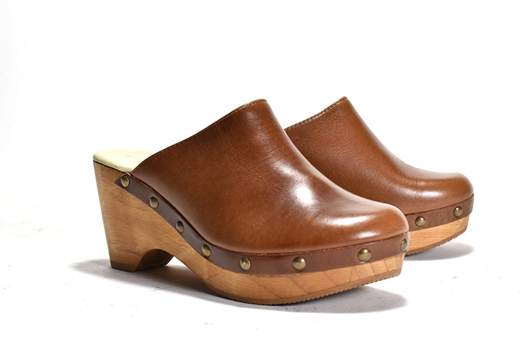 pair of brown leather clog with a wooden heel and platform, featuring metal eyelets