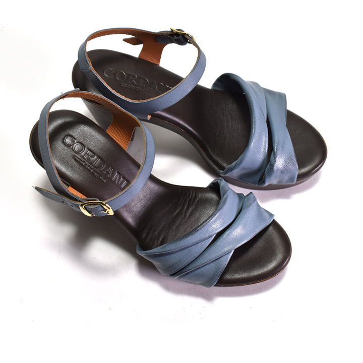 Pair of sandals with blue straps and black soles on a white background