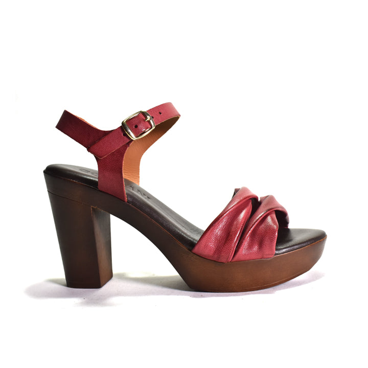 Red high-heeled sandal with a brown platform on a white background