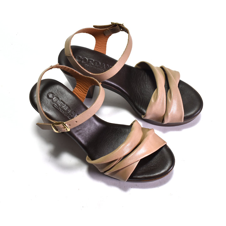 Pair of sandals with tan straps on a white background