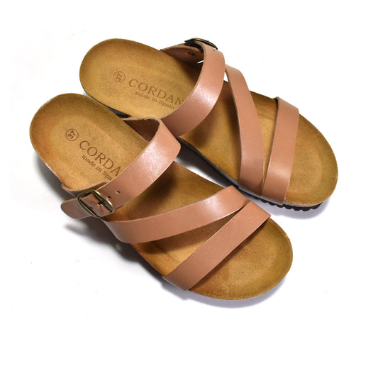 Pair of tan sandals with brown soles on a white background