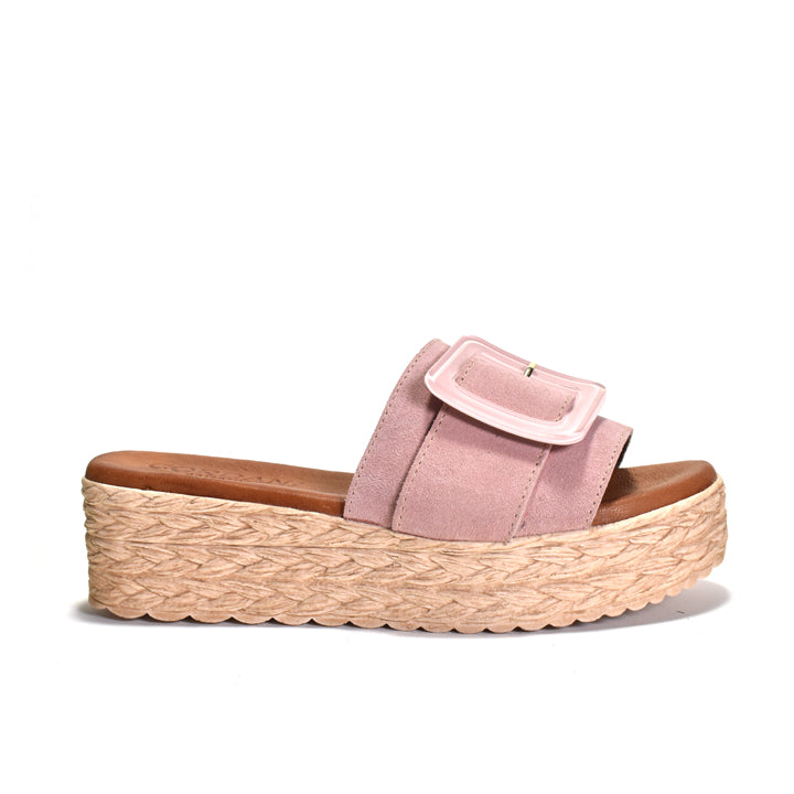 Pink sandal with a woven platform sole on a white background