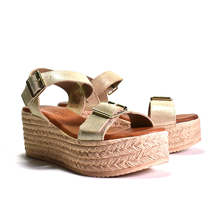 pair of metallic sandal with a buckle strap and a textured platform sole.