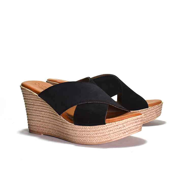 Black pair of wedge sandal with espadrille sole on a white background