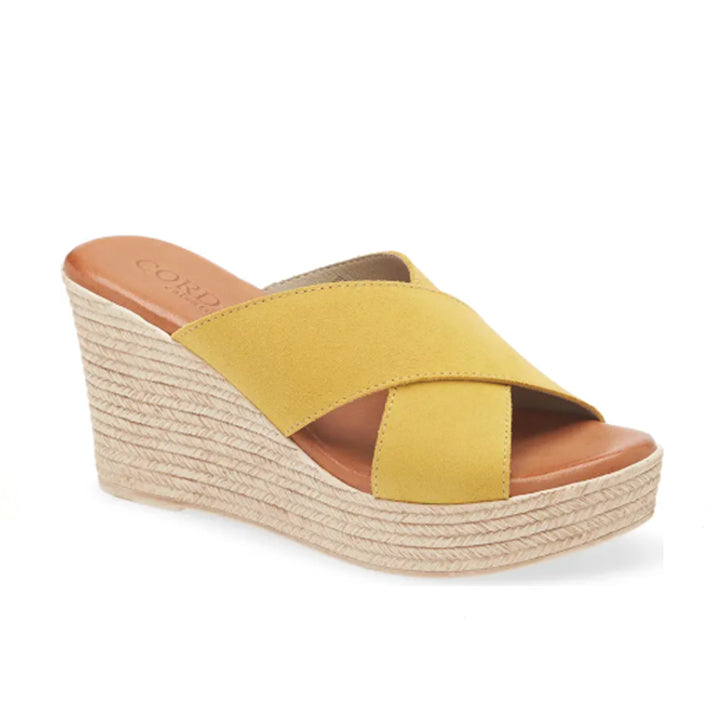Yellow wedge sandal with brown sole on a white background