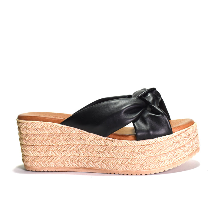 Black wedge sandal with a bow on a white background