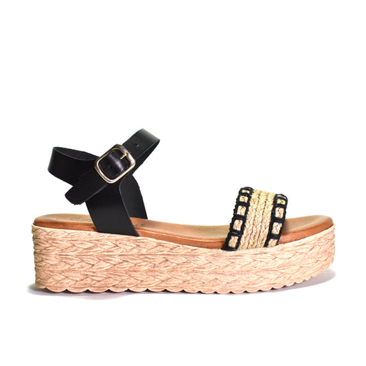 Black strap sandal with woven sole on a white background