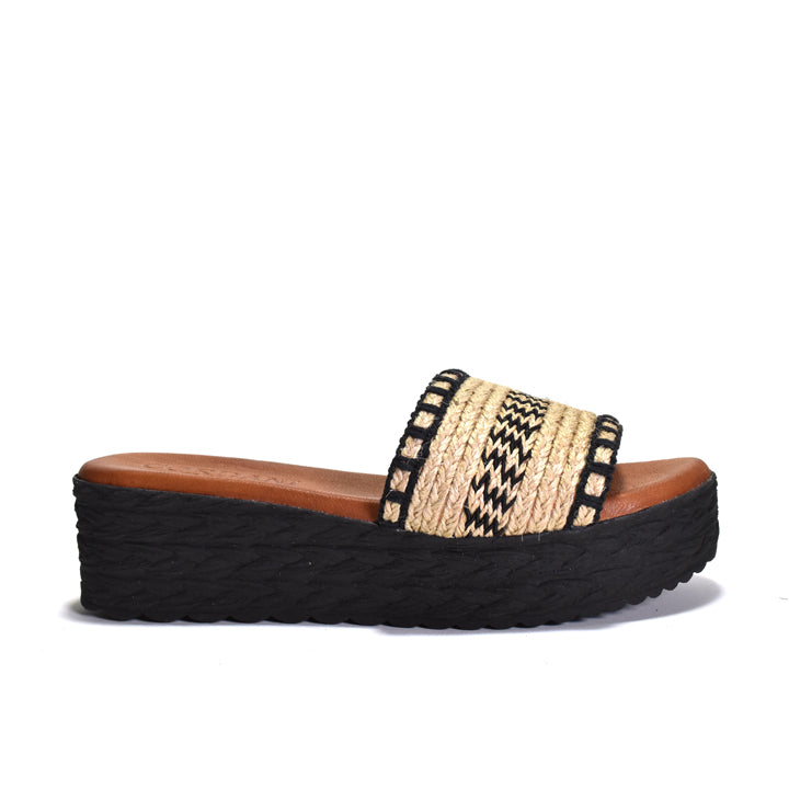 Woven sandal with a black platform sole on a white background
