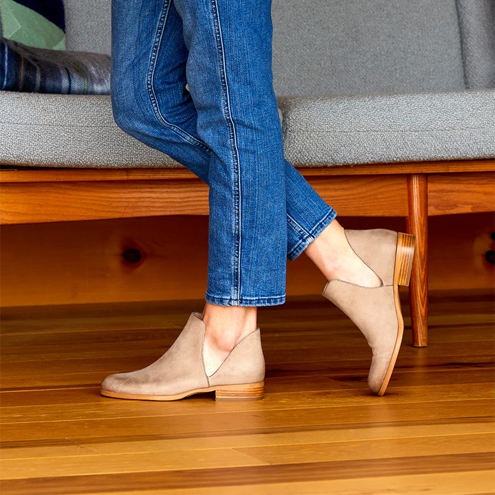 beige suede ankle boot with a stacked heel and a cut-out side