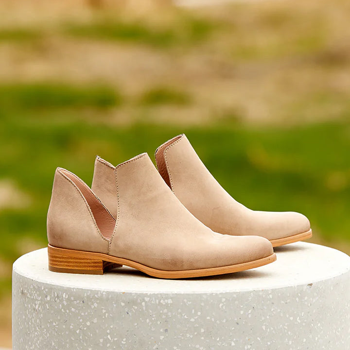 beige suede ankle boot with a stacked heel and a cut-out side