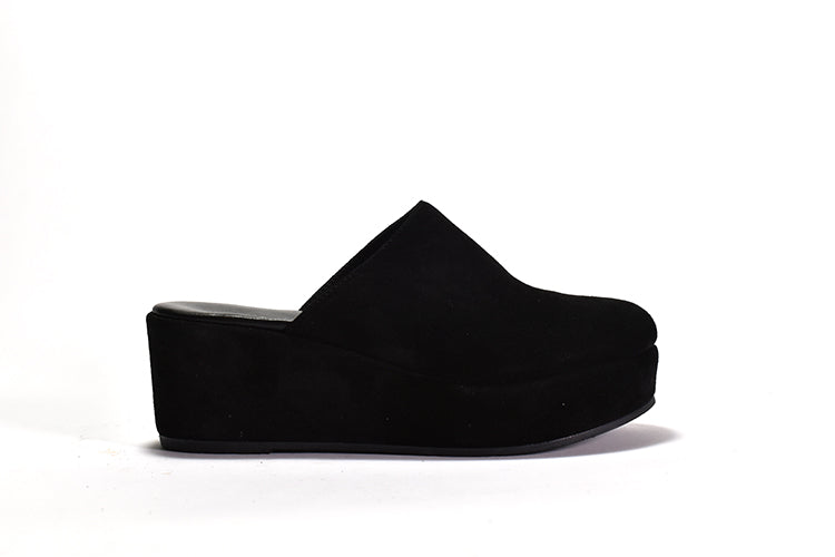 A black suede clog with a platform sole and lightly padded leather footbed, set against a white background.