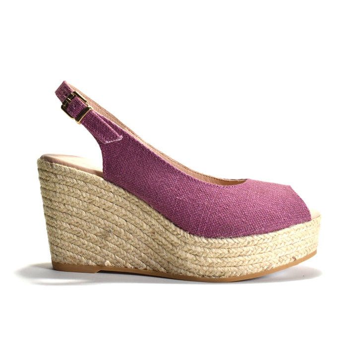 Purple wedge sandal with a textured sole on a white background