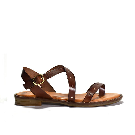 A pair of brown faux leather sandals with a crisscross toe ring design and gold stud details