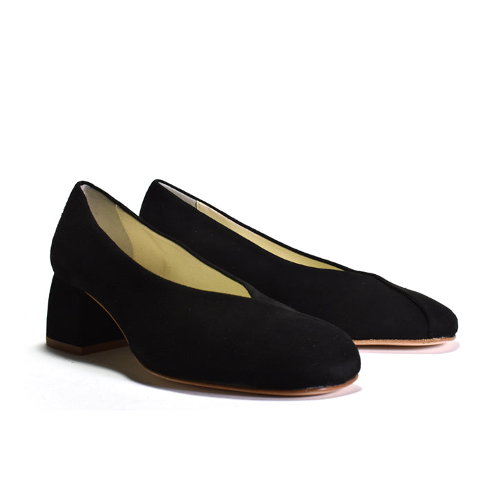 A pair of black suede block-heel pumps with a rounded toe, displayed on a clean white background.