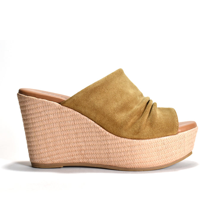Wedge sandal with suede upper and woven sole on a white background