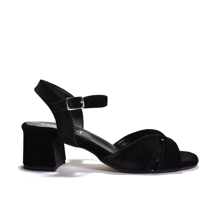 A single black velvet block-heel sandal with an ankle strap and a small silver buckle, shown from a side profile on a white background.