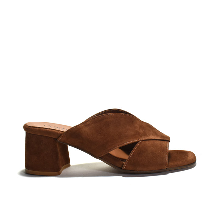 A single brown suede mule sandal with a block heel and crisscrossing front straps, shown from a side profile on a white background.