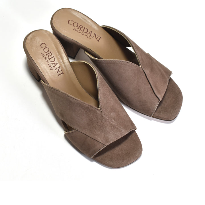 A pair of Cordani taupe-brown suede mule sandals with a low block heel and criss-cross strap design, displayed on a clean white background.