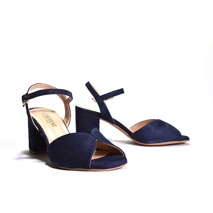 A navy blue suede sandal with an ankle strap and a wrapped block heel