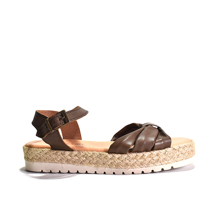 dark brown nappa leather sandal with a woven rafia wrapped wedge, leather lining, and an adjustable buckle strap on a white background.