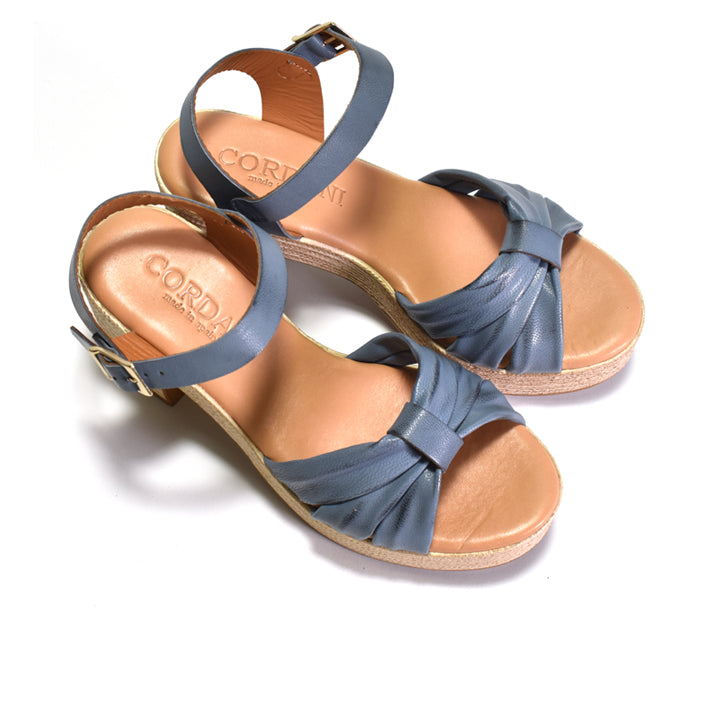 Pair of blue sandals with tan soles on a white background
