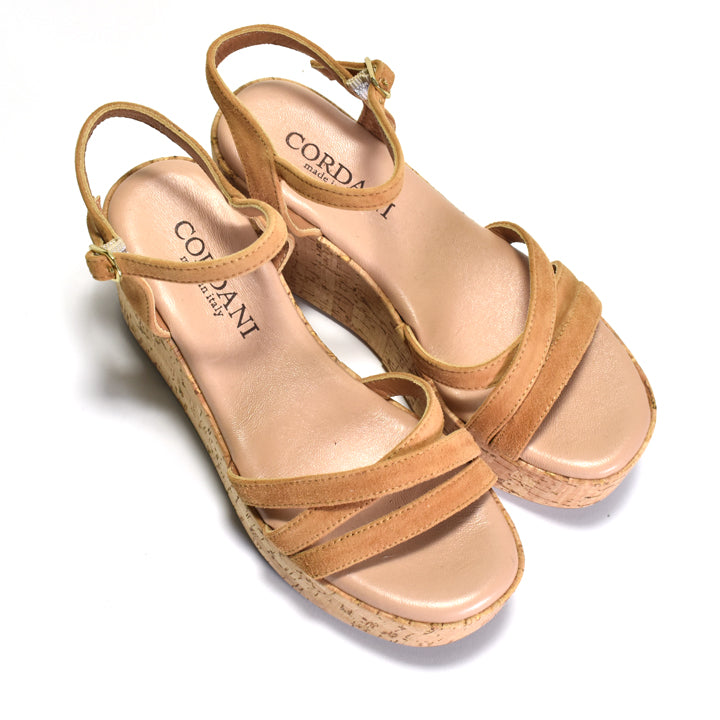 pair of brown suede sandals with a triple band upper and a quarter strap, featuring a cork wrapped wedge and an adjustable metal buckle.