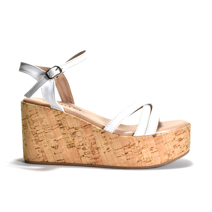 white leather sandals with a triple band upper and a quarter strap, featuring a cork wrapped wedge and an adjustable metal buckle.
