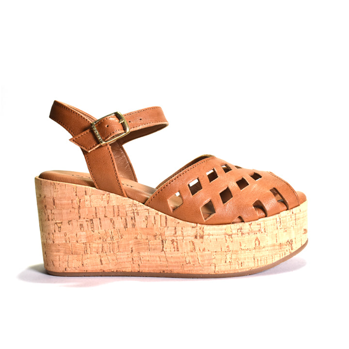 Brown laser-cut wedge sandal with cork platform on a white background