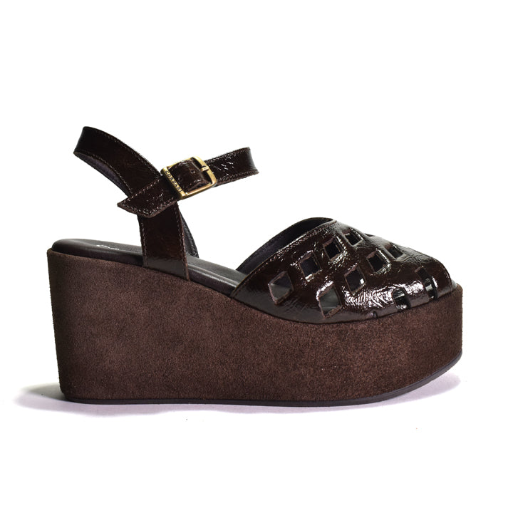 A dark brown platform wedge sandal with a glossy crinkle-embossed toe strap, a buckle ankle strap, and a textured brown wedge heel, shown against a plain white background.