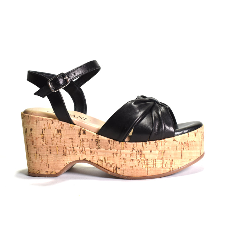 Black sandal with cork wedge sole on a white background
