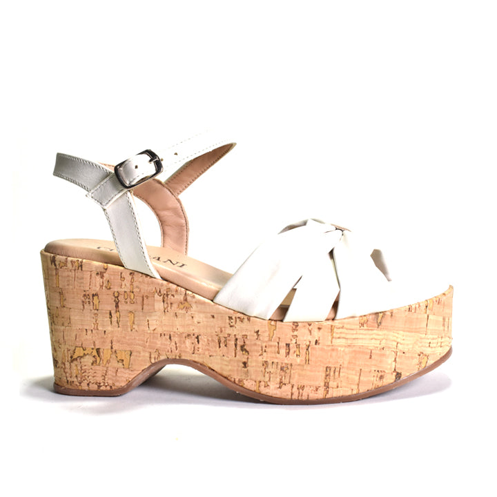 White sandal with cork wedge sole on a white background