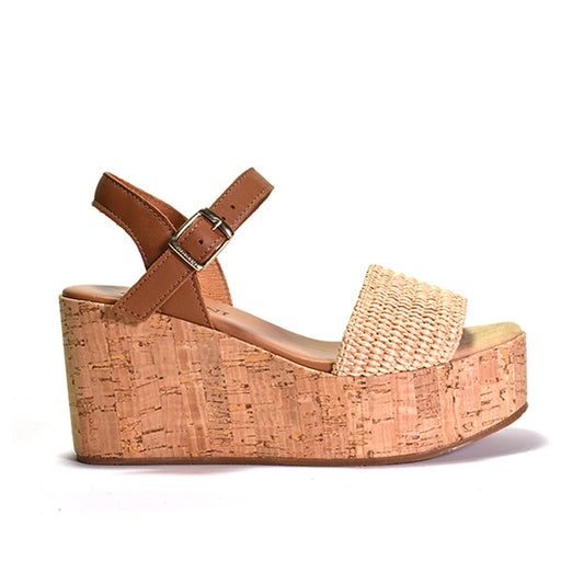 A brown wedge sandal with a leather upper and lining, a cork-wrapped wedge, and a lightly padded leather footbed, featuring a quarter strap and an adjustable metal buckle.