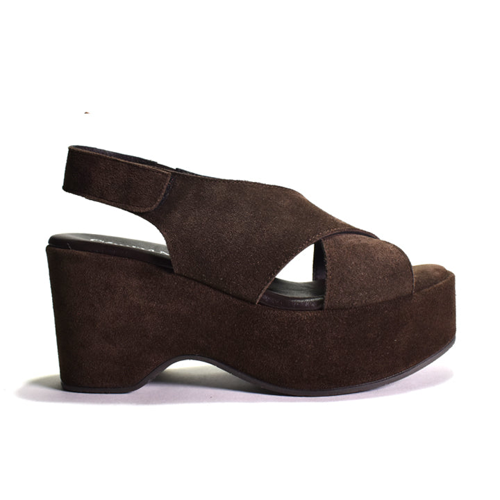 A dark brown suede platform wedge sandal with crisscrossing straps and a slingback design, shown from a side profile on a white background.