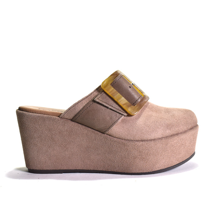 A single women's platform wedge mule shoe in taupe suede with a brown leather strap and a translucent amber buckle, shown from a side profile on a white background.