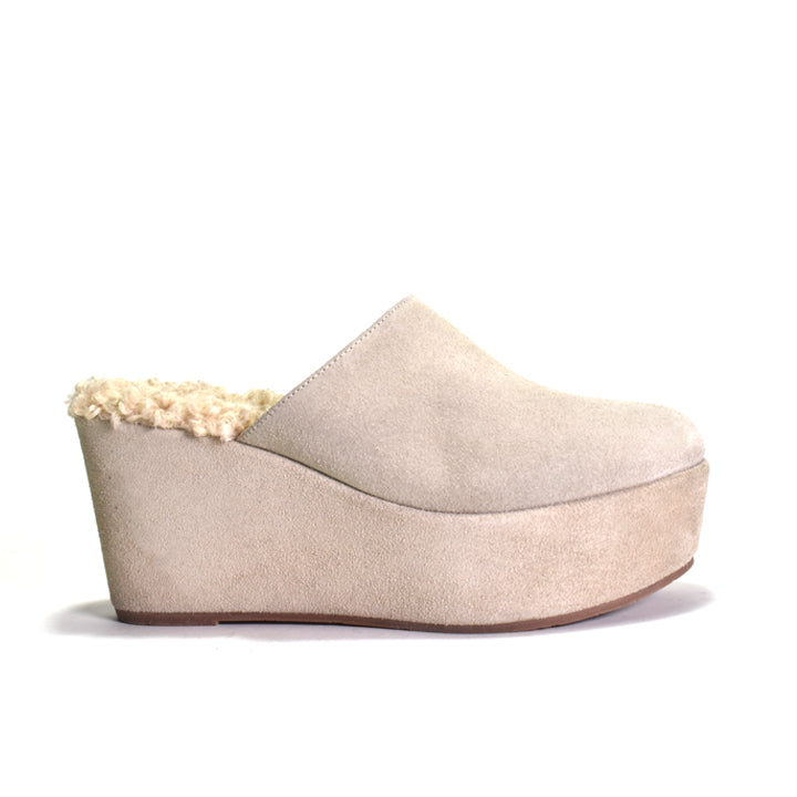 Beige wedge clog with faux sheerling footbed on a white background