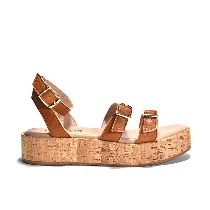 A brown two-strap sandal with adjustable metal buckles, a cork-wrapped platform, and a leather ankle strap.